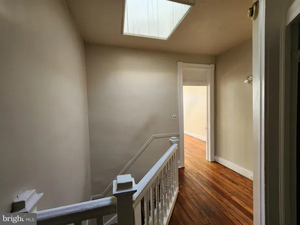 a view of a hallway with wooden floor and stairs