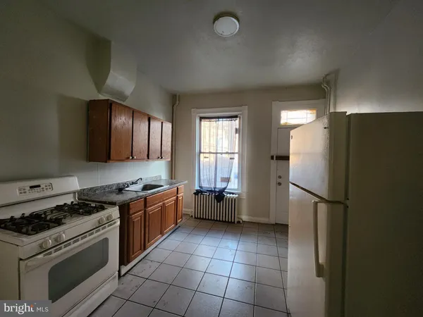 a kitchen with a stove a refrigerator and a sink