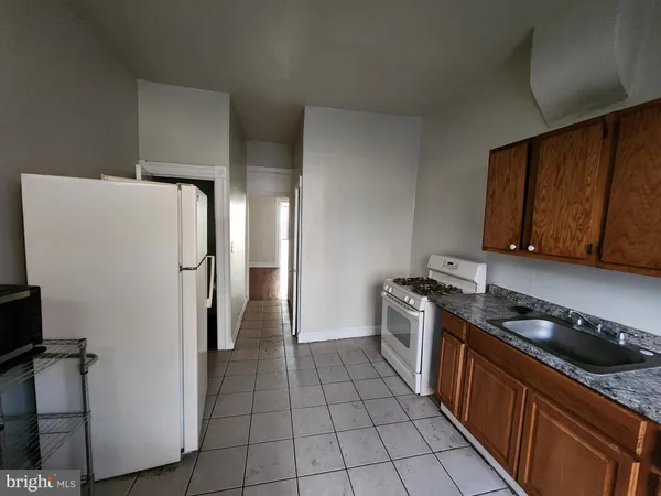 a kitchen with stainless steel appliances granite countertop a refrigerator a stove and a sink