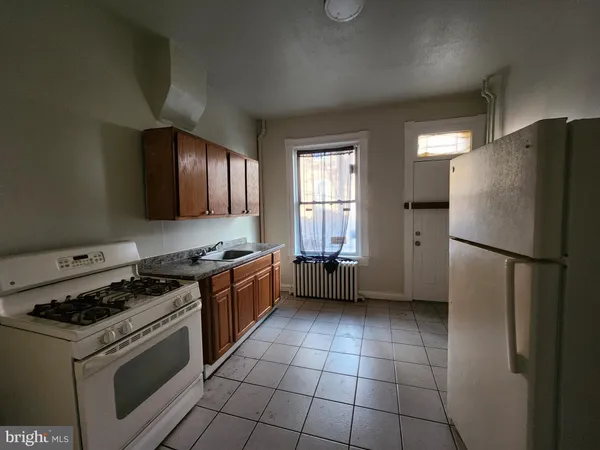 a kitchen with a stove a refrigerator and a sink