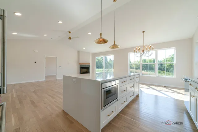a kitchen with stainless steel appliances granite countertop a stove and a wooden floors