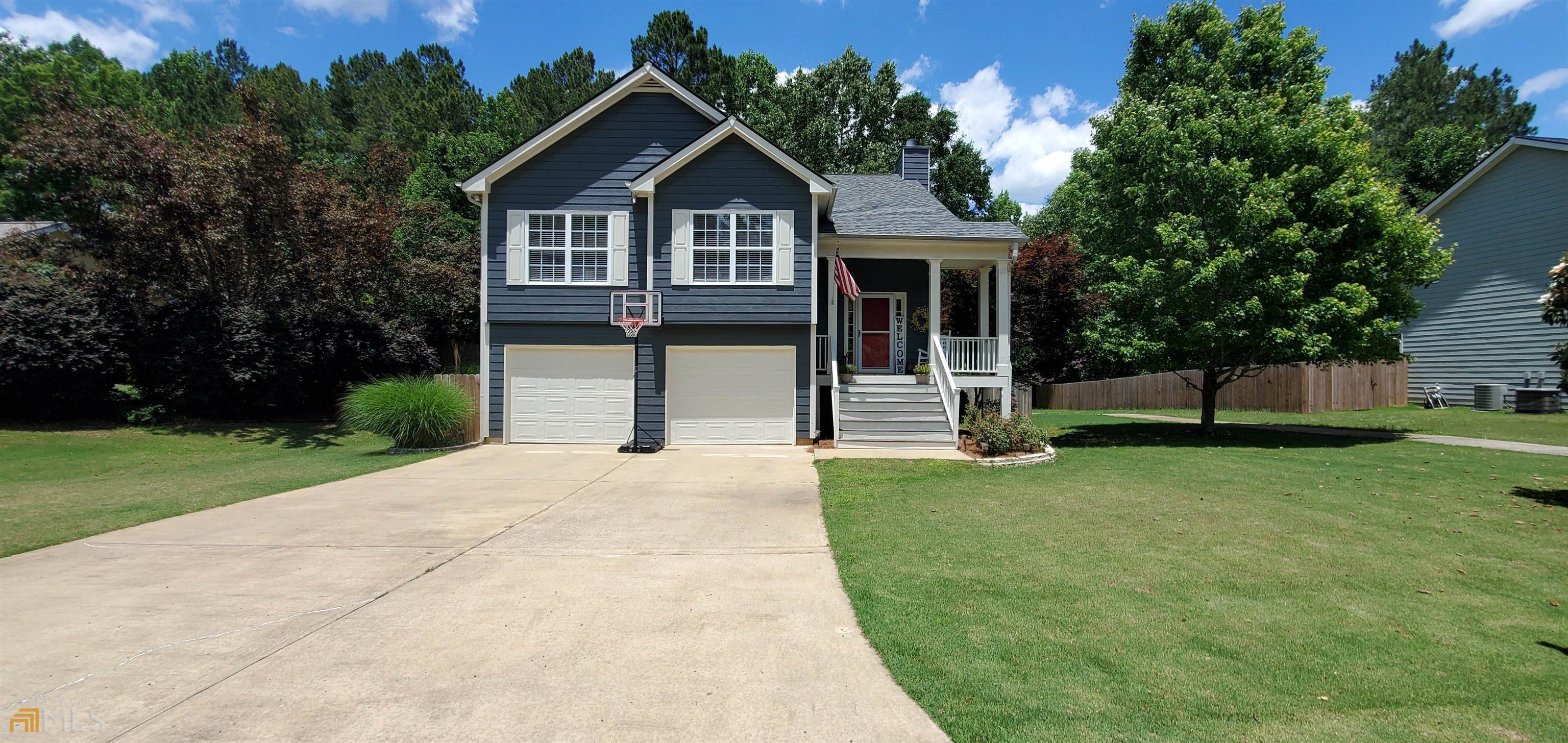 a front view of a house with a yard and trees