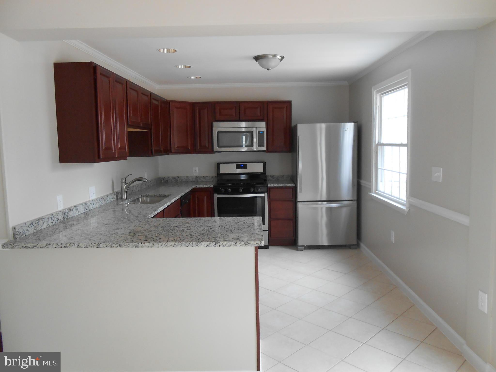 2405 Meadow Road Baltimore, MD 21222 - Photo 3 of 13 a kitchen with granite countertop a refrigerator and a sink
