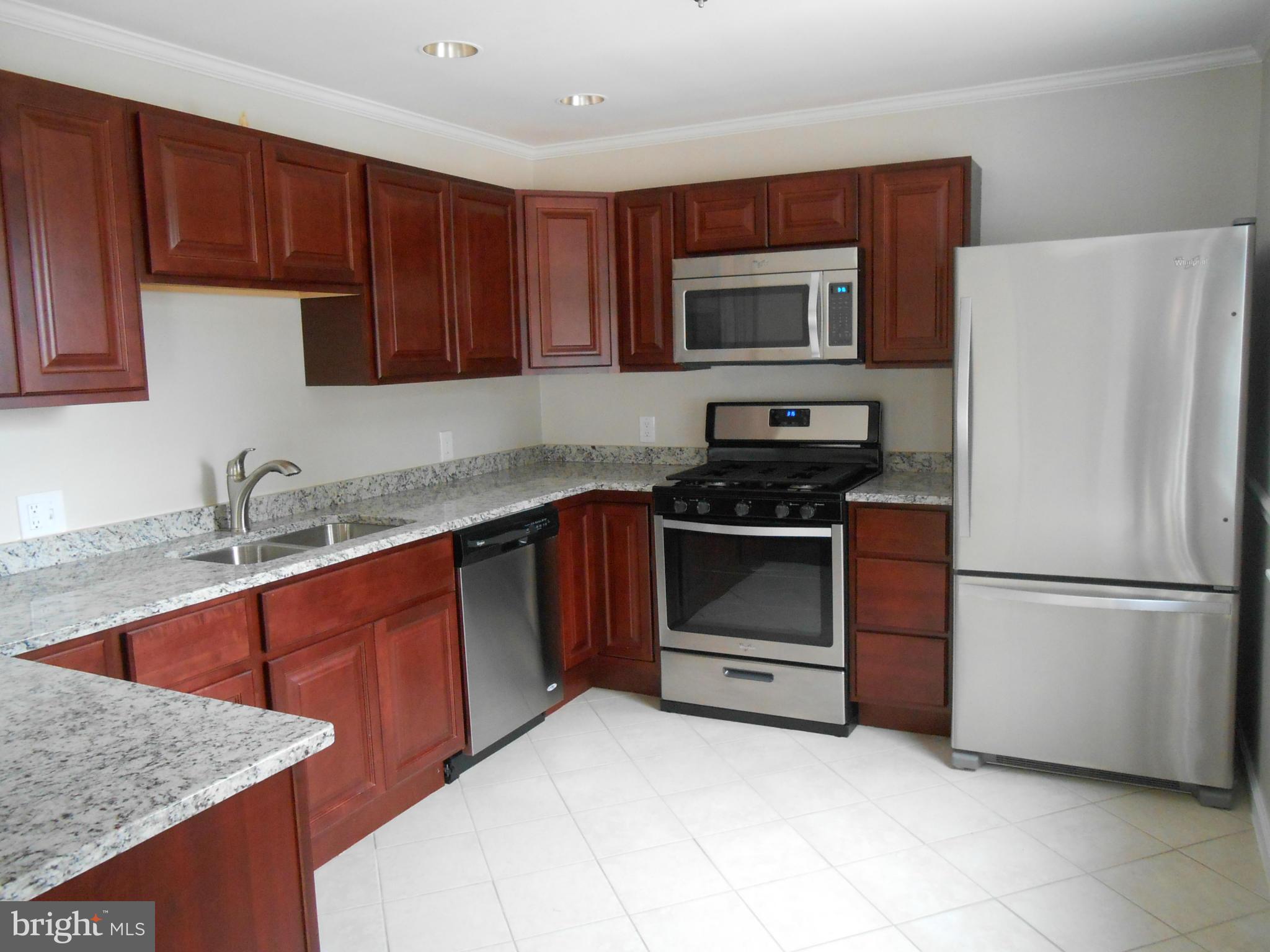 2405 Meadow Road Baltimore, MD 21222 - Photo 4 of 13 a kitchen with granite countertop a refrigerator stove and microwave