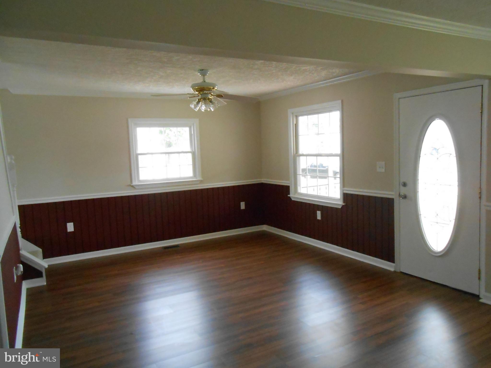 2405 Meadow Road Baltimore, MD 21222 - Photo 5 of 13 an empty room with wooden floor and windows
