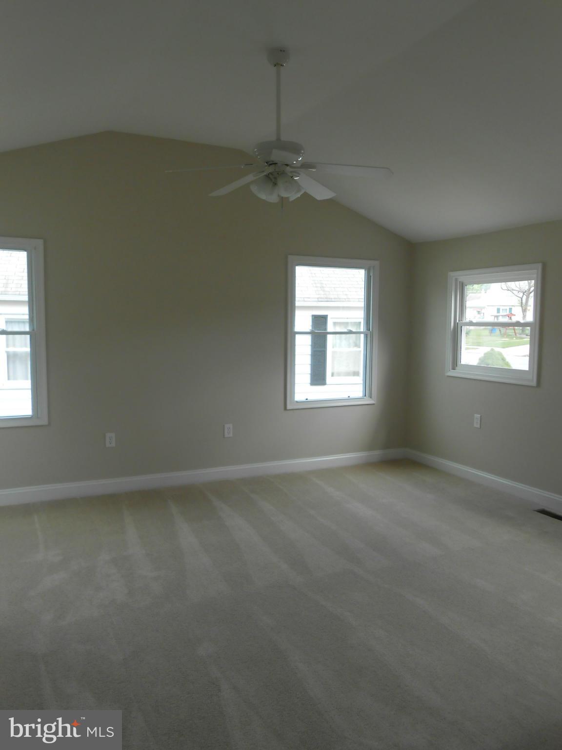 2405 Meadow Road Baltimore, MD 21222 - Photo 7 of 13 an empty room with windows and chandelier fan