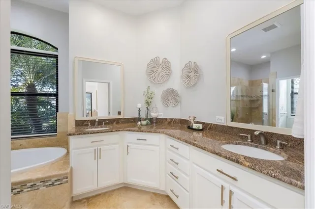 a bathroom with a granite countertop sink mirror and bathtub