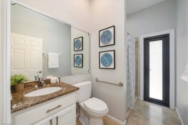 a bathroom with a granite countertop toilet sink and mirror