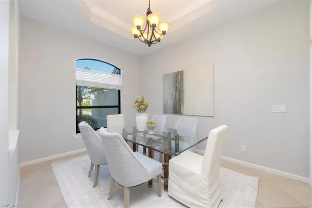 a view of a dining room with furniture a chandelier and wooden floor