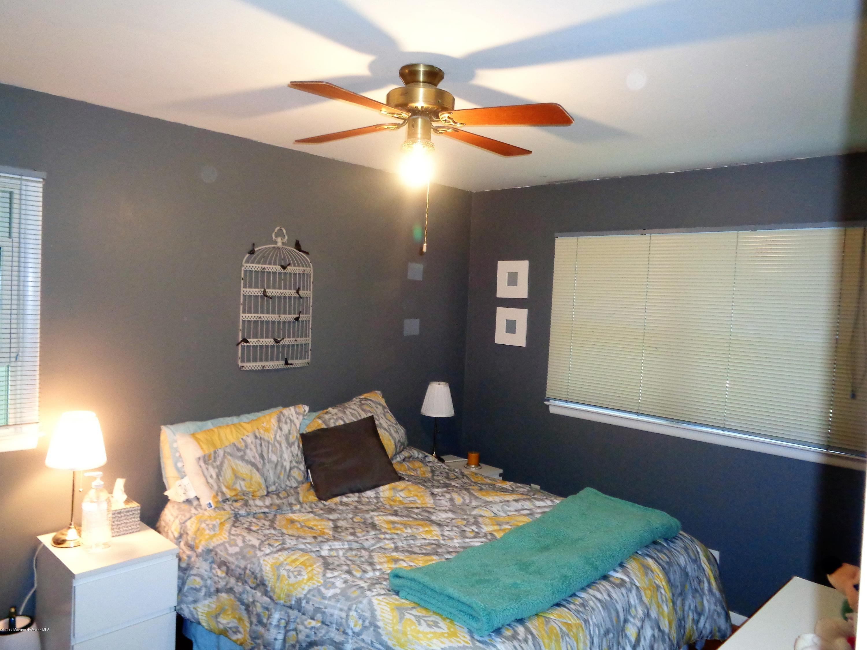 25 Pepperridge Road Howell, NJ 07731 - Photo 13 of 28 a bedroom with a bed and a chandelier