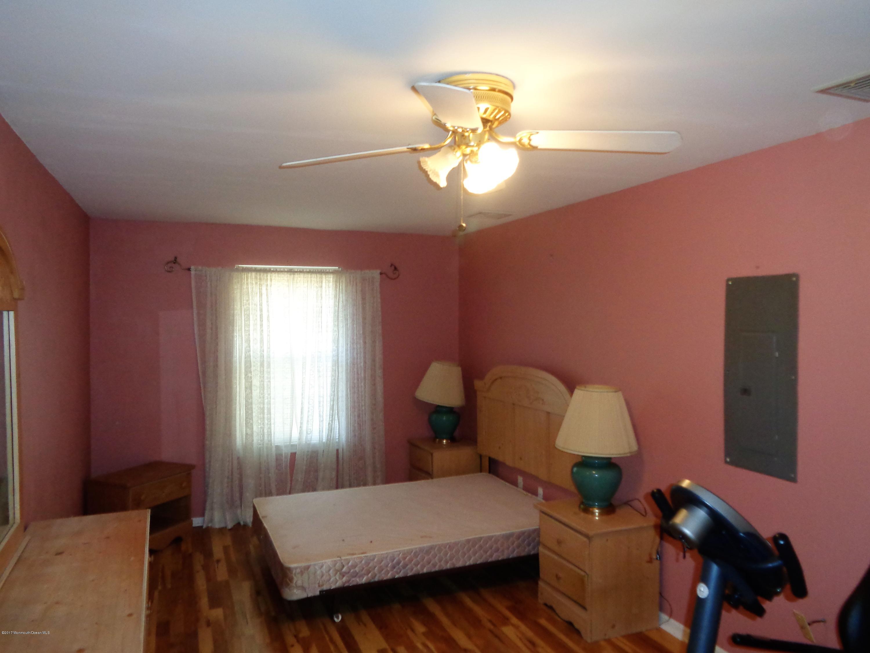 25 Pepperridge Road Howell, NJ 07731 - Photo 26 of 28 a bedroom with a bed and a chandelier