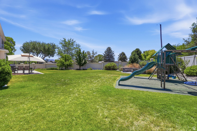 10676 Urban Rdg Cove South Jordan, UT 84095 - Photo 48 of 48 Expansive green lawn with a dedicated play structure featuring a slide and swings
