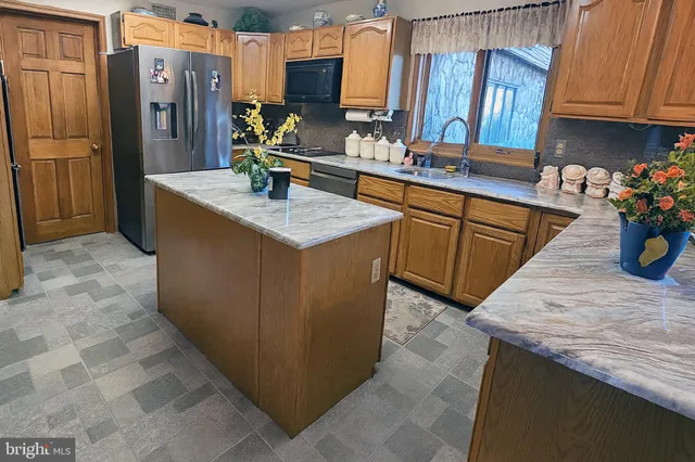 a bathroom with a granite countertop sink mirror and window
