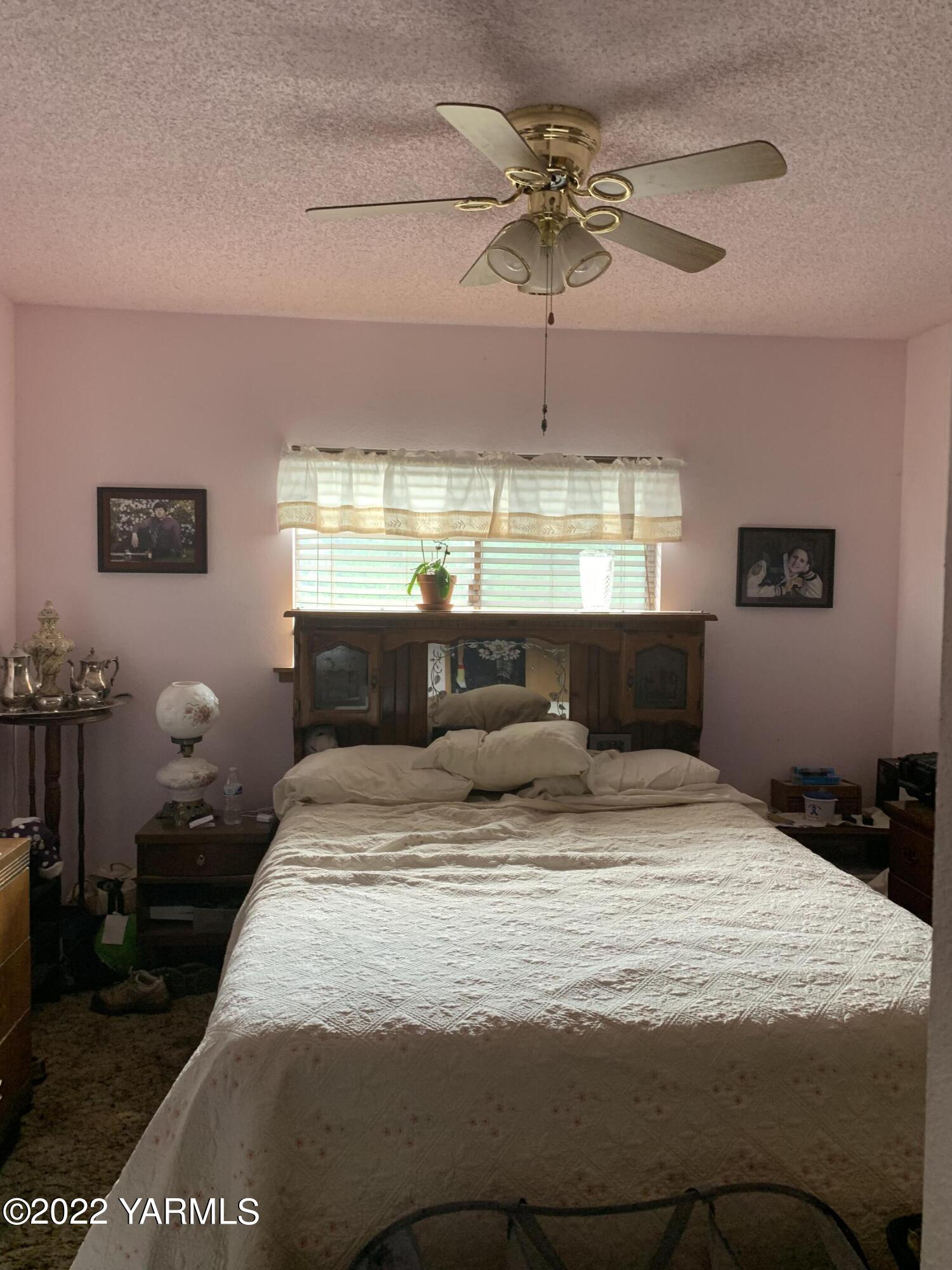 11105 Occidental Road Yakima, WA 98903 - Photo 24 of 30 a bedroom with a bed and a chandelier