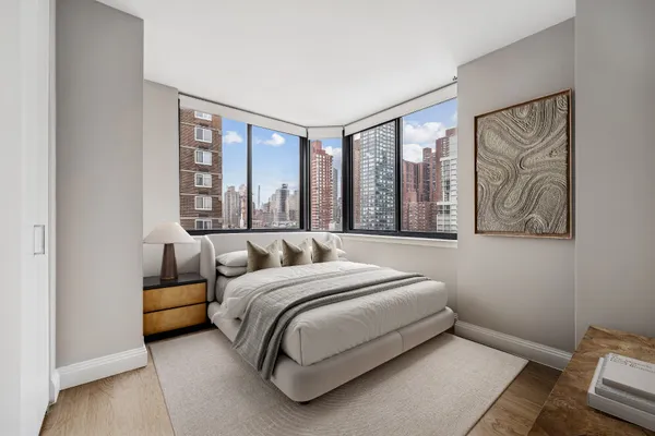a bedroom with a bed couch and a large window