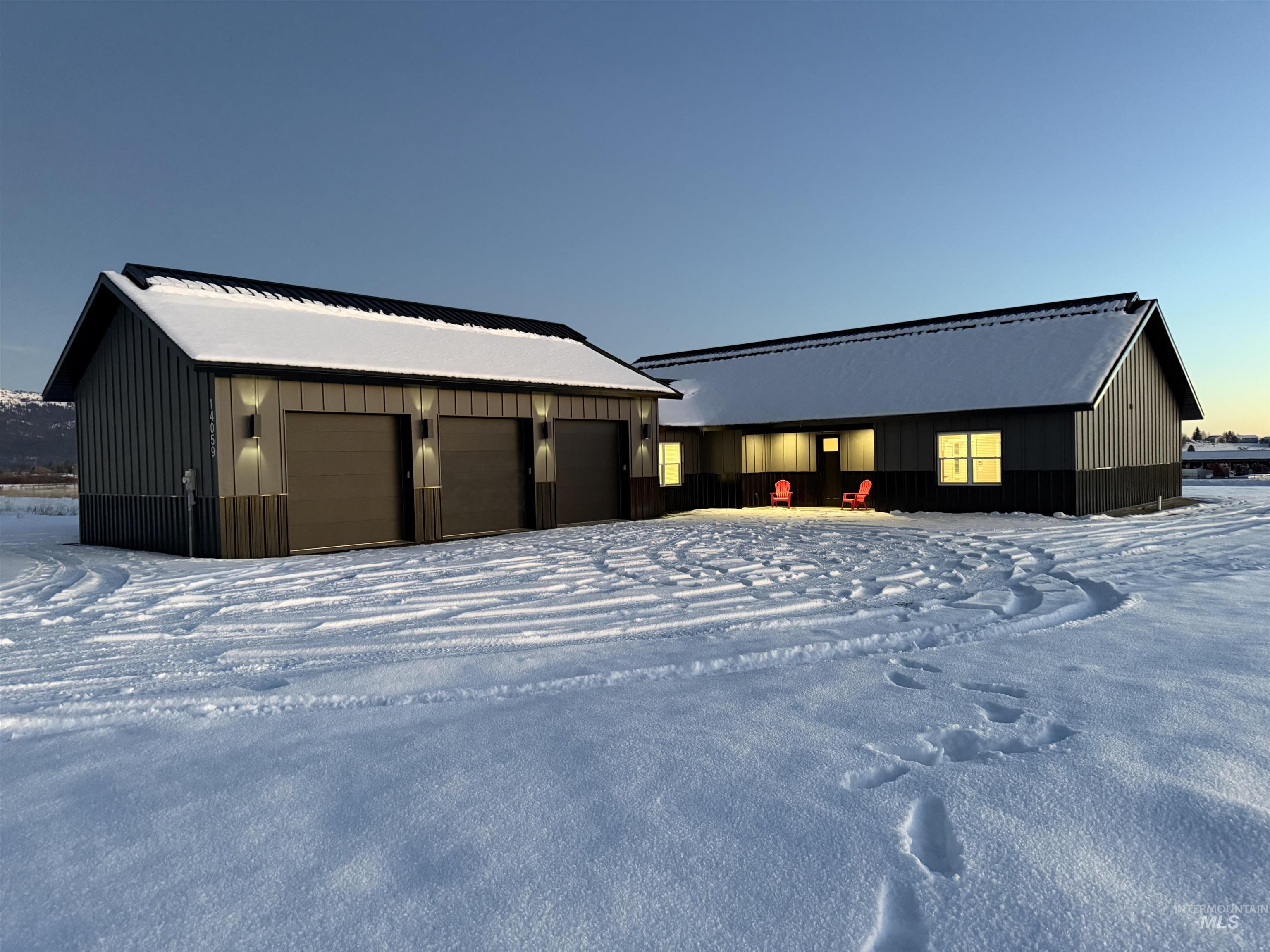 Snow covered property featuring a garage