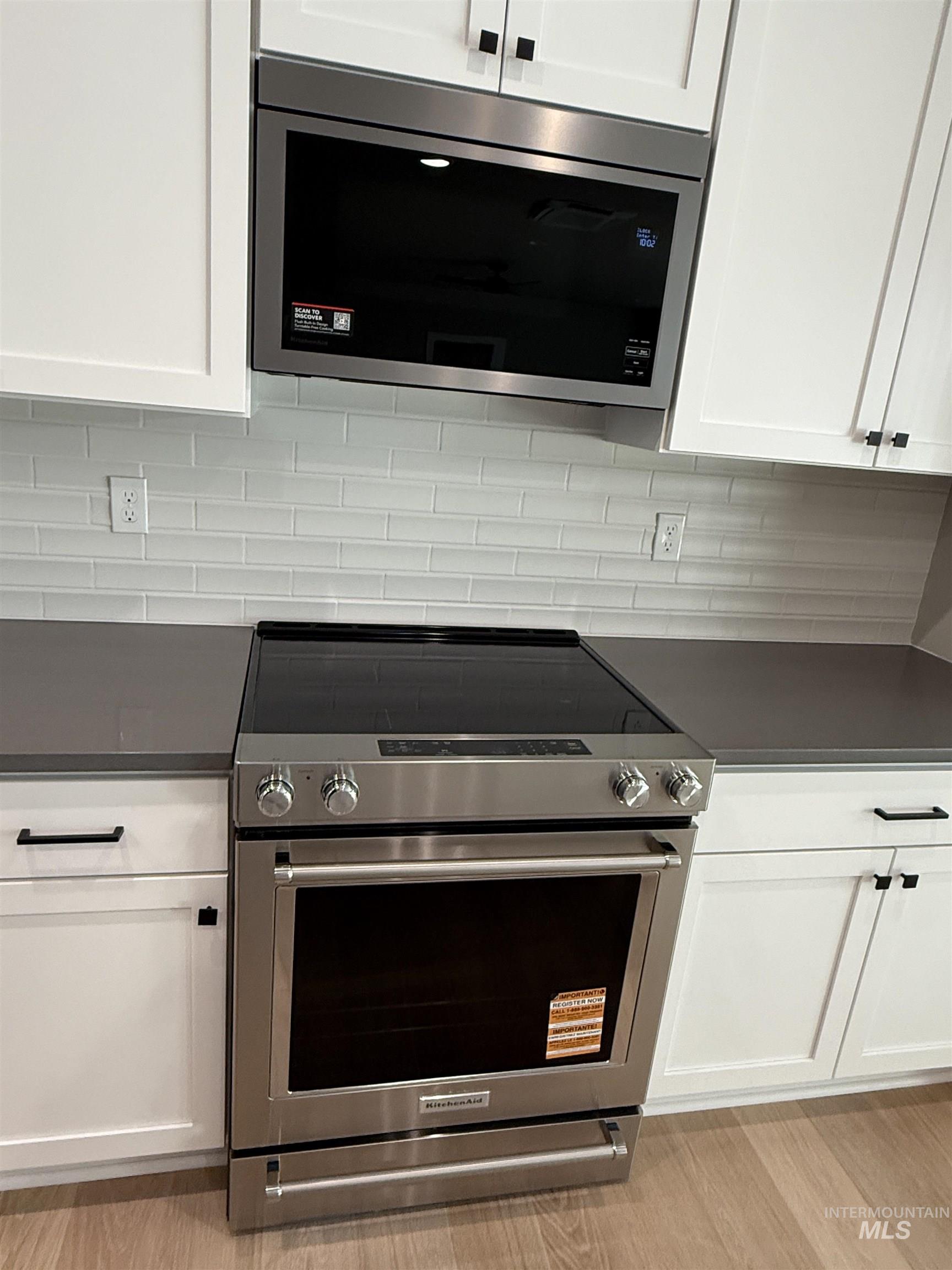 14059 Mulberry McCall, ID 83638 - Photo 8 of 32 Kitchen with stainless steel appliances, dark countertops, and white cabinetry