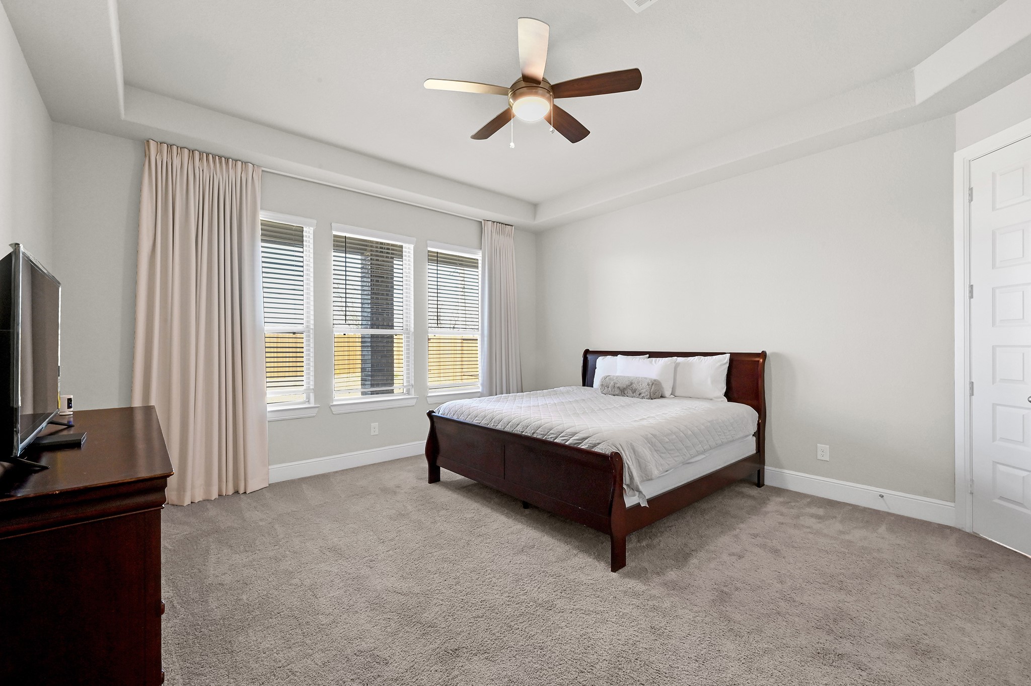 8 Palmero Way Manvel, TX 77578 - Photo 14 of 34 a spacious bedroom with a bed flat screen tv closet and a large window