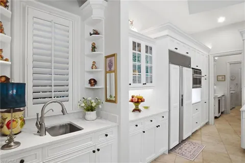 a bathroom with a sink a potted plant and a large mirror