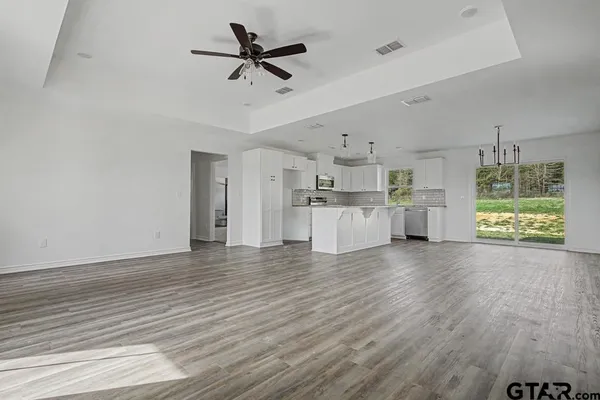 a view of a kitchen with wooden floor and a window