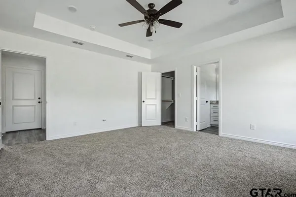 an empty room with closet and windows