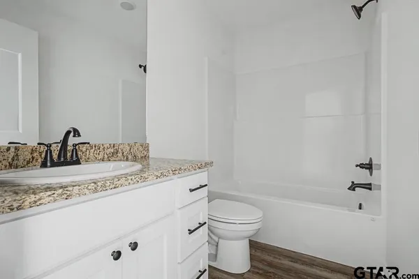 a bathroom with a granite countertop sink toilet and shower