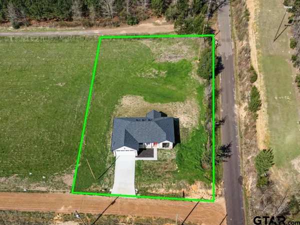 an aerial view of a house with a yard