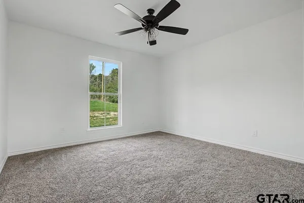 an empty room with a window and a fan