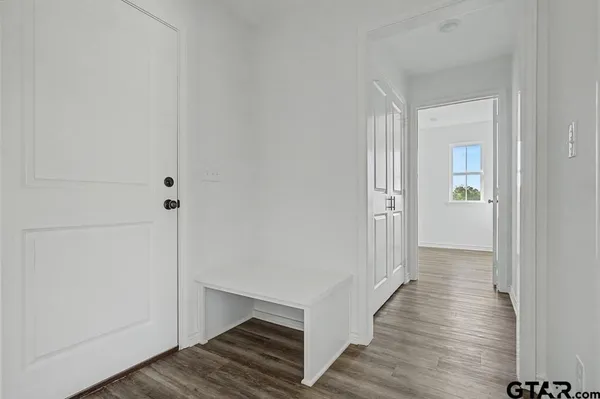 a view of a hallway with wooden floor and staircase