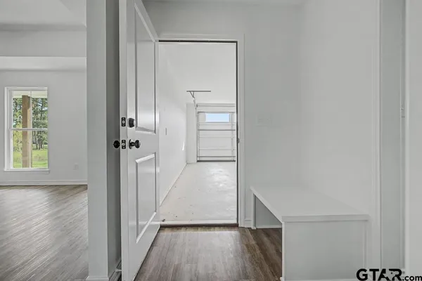 a view of a hallway with wooden floor and staircase