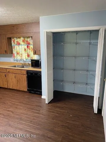 a view of a kitchen with wooden floor and electronic appliances