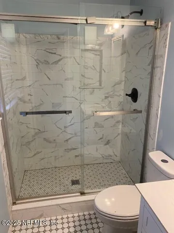 a bathroom with a shower a toilet and a sink