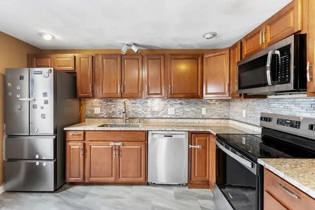 a kitchen with stainless steel appliances granite countertop a stove a refrigerator and a microwave