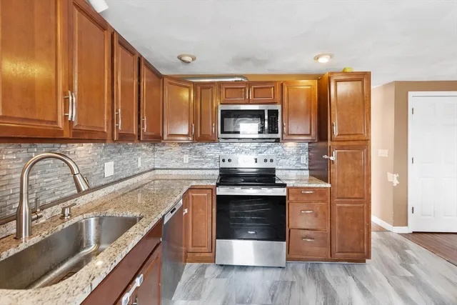 a kitchen with stainless steel appliances granite countertop a stove a sink and a microwave