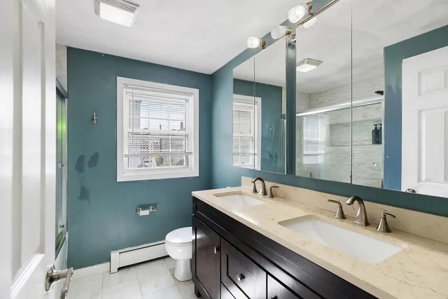 a bathroom with a granite countertop sink a toilet and a mirror