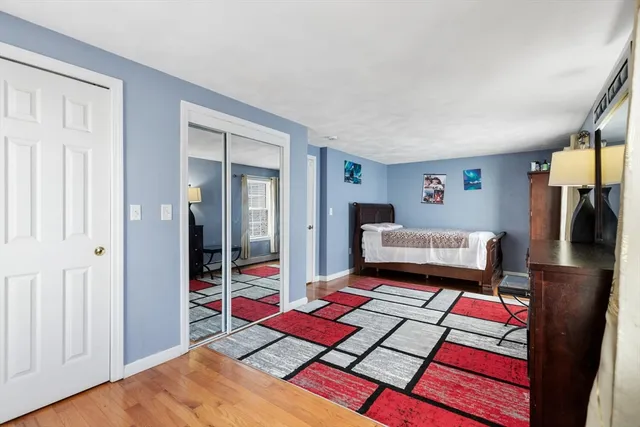 a bedroom with a bed and a dresser next to a window