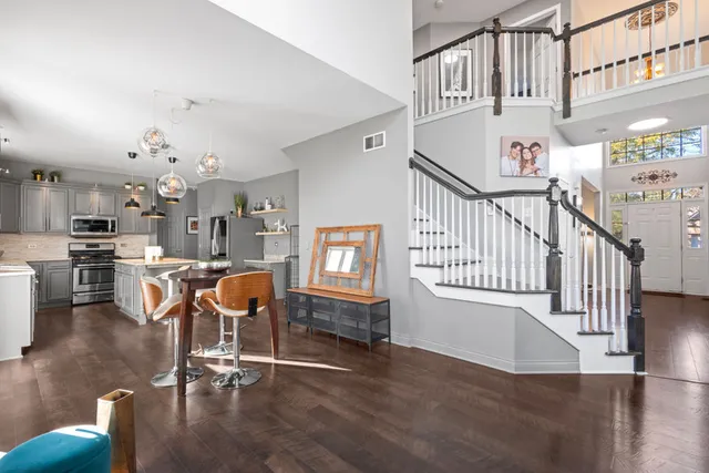 a bedroom with a bed and dresser with wooden floor