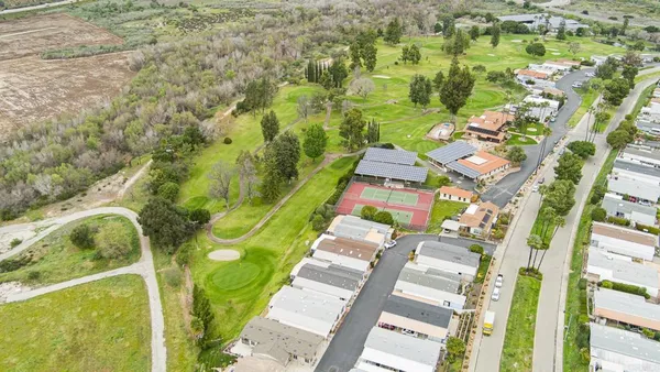 an aerial view of residential houses with outdoor space and street view