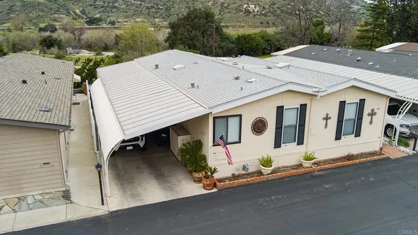 an aerial view of a house with a garden and lake view