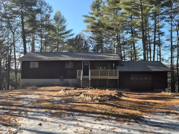 a front view of a house with a yard covered with snow