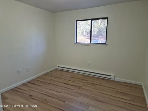 a view of room with wooden floor