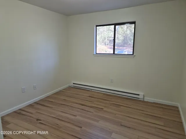 a view of room with wooden floor
