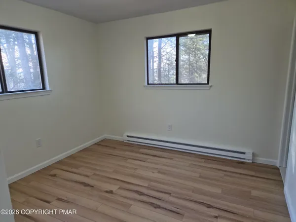 a view of empty room with wooden floor