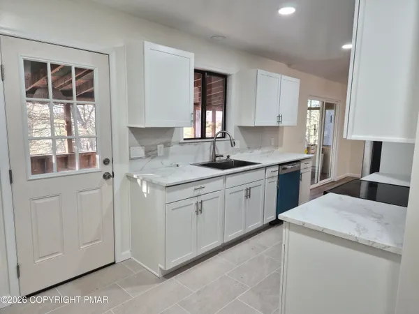 a kitchen with a white cabinets and window