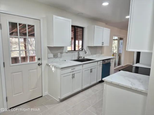 a kitchen with a white cabinets and window