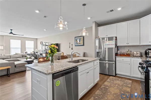 a kitchen with stainless steel appliances granite countertop a sink stove and refrigerator