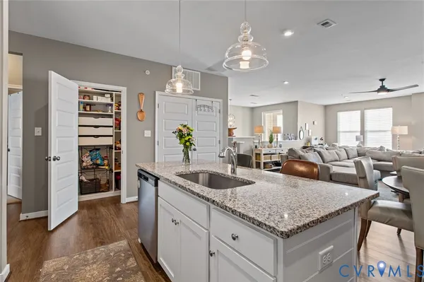a kitchen with granite countertop a sink a counter cabinets and appliances