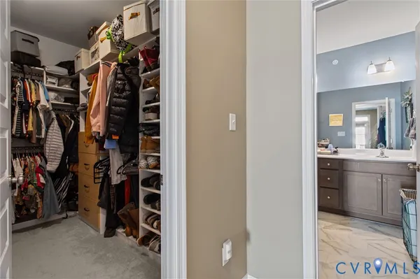 a view of walk in closet with clothes and shoes