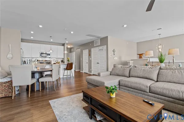 a living room with furniture and a dining table with kitchen view