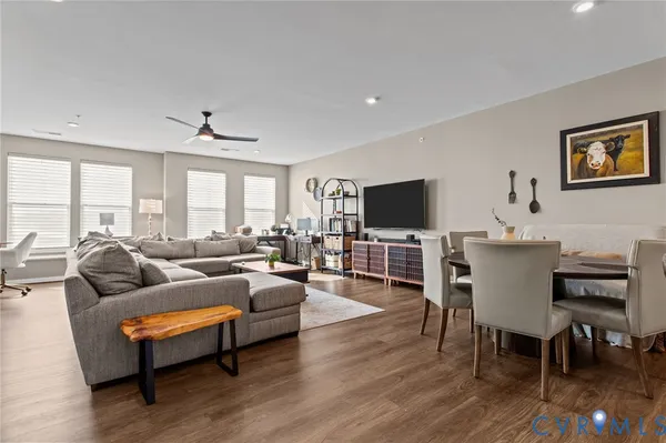 a living room with furniture flat screen tv and wooden floor